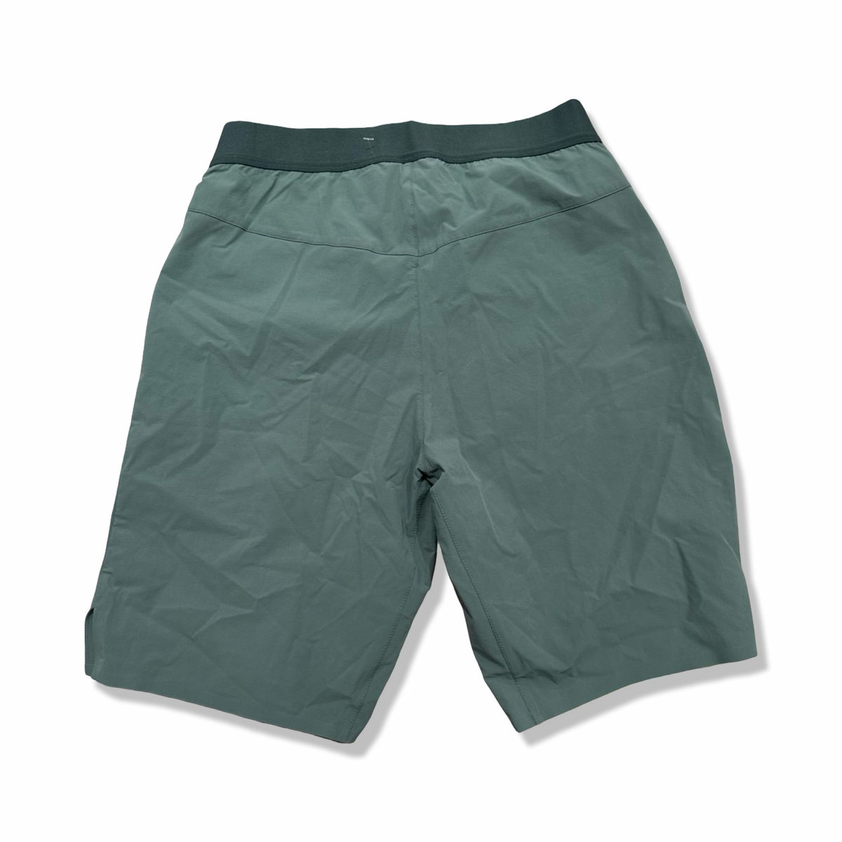 Baksidan av ett par gröna Salomon Wayfarer Pull On Short funktionsshorts för herr, fotograferade mot en vit bakgrund.