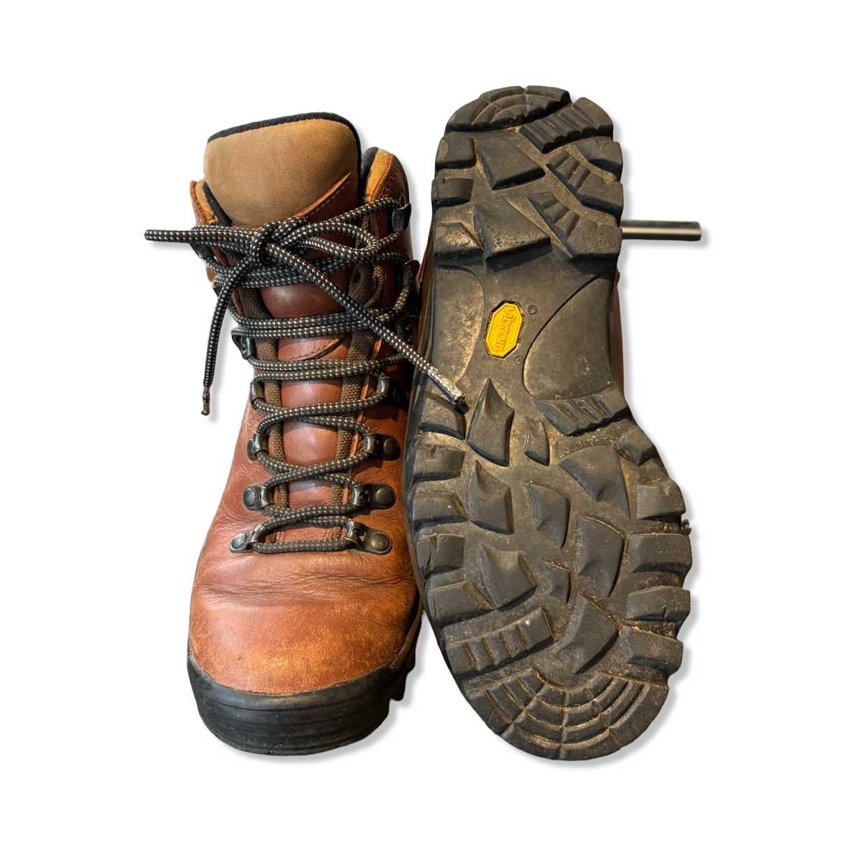Bruna Merrell-vandringskängor i läder med snörning och kraftiga Vibram-gummisulor, där den ena skon visar yttersulan.