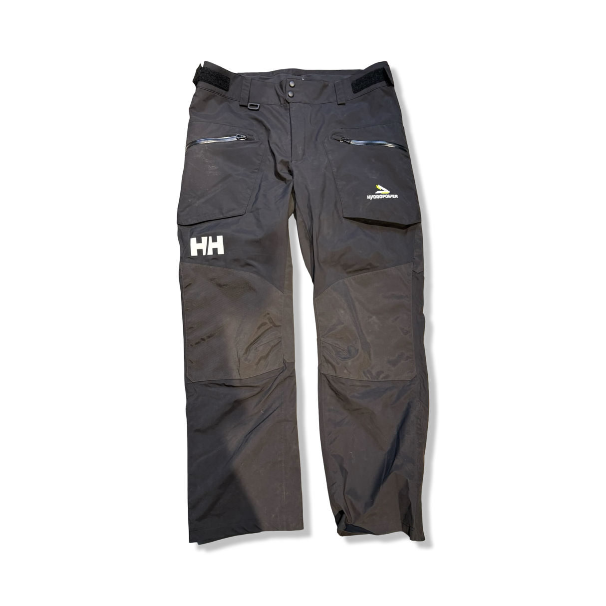Svart Helly Hansen HP Foil seglarbyxa för herr med dragkedja och förstärkta knän, fotograferad framifrån mot en vit bakgrund.