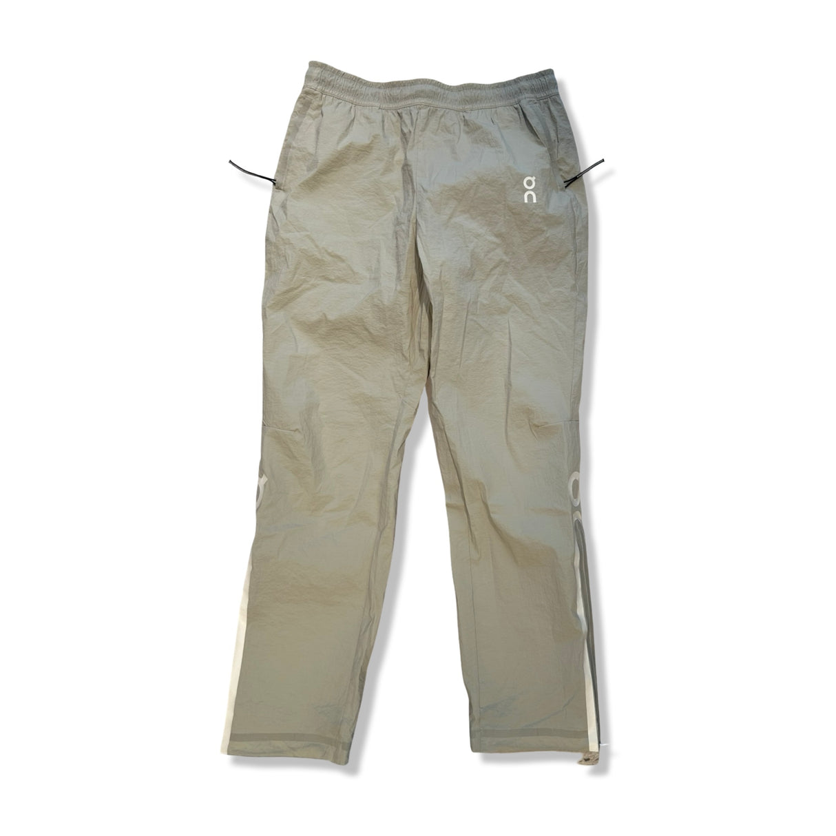 Beige funktionsbyxor från ON Track Pants IKON för herr, fotograferade framifrån mot en vit bakgrund.
