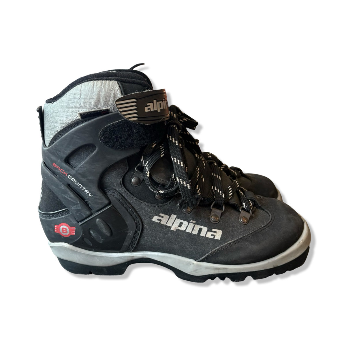 Svarta Alpina BC 1550 backcountry pjäxor för dam i modell med snörning och kardborreband, fotograferade från sidan mot vit bakgrund.