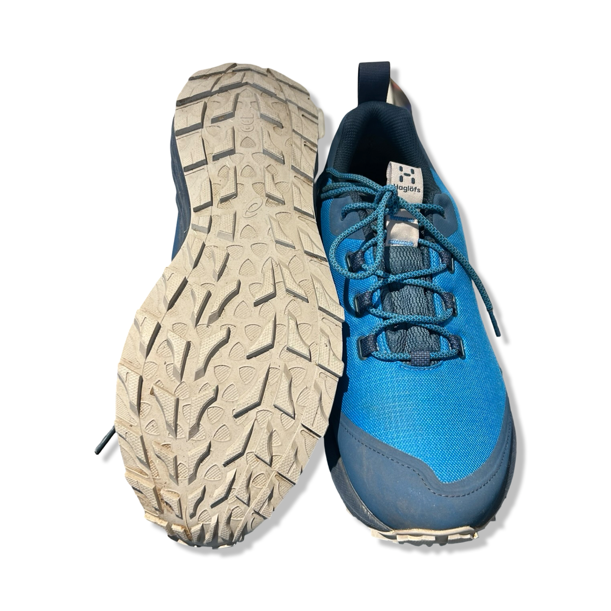 Underside and front view of a blue men's hiking shoe from Haglöfs, photographed against a white background.