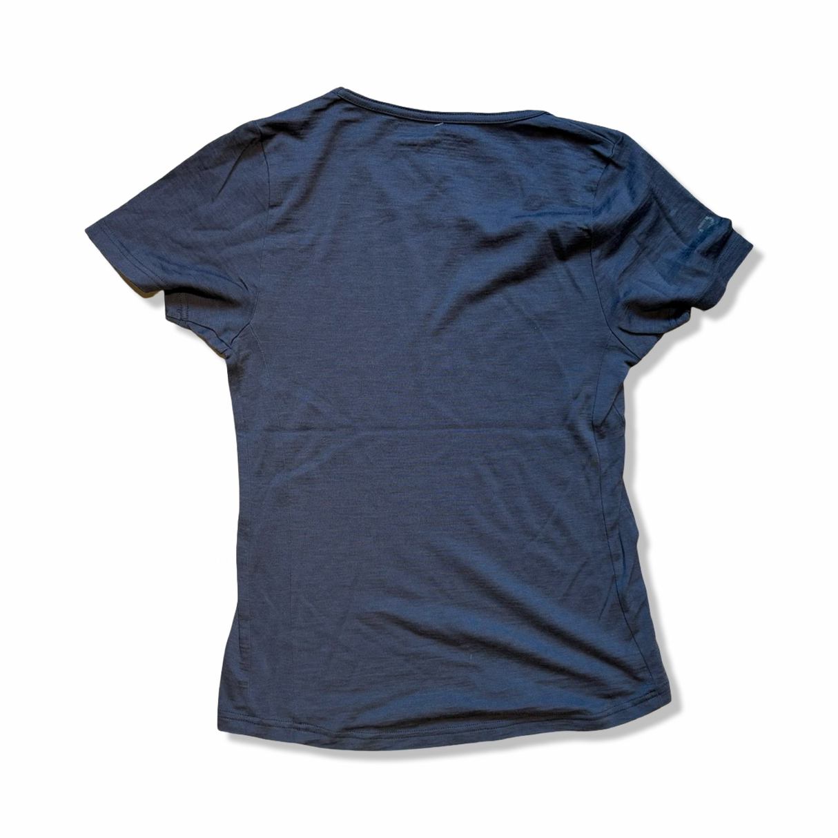 Baksidan av en grå T-shirt från Ortovox i modell M, fotograferad mot en vit bakgrund.