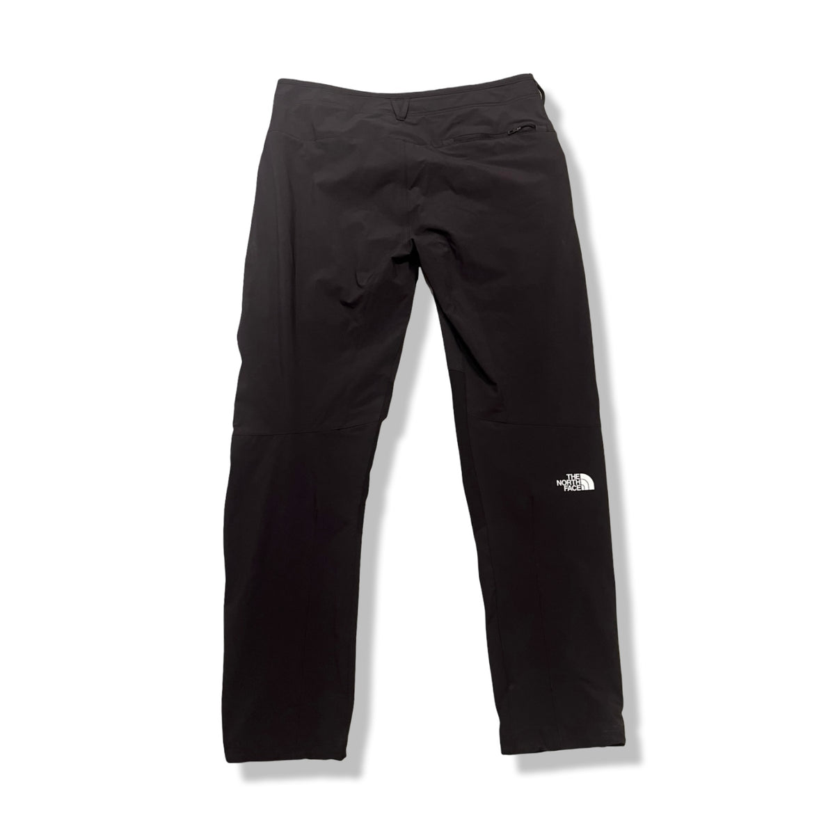 Back view of a pair of black The North Face men's softshell trousers against a white background.