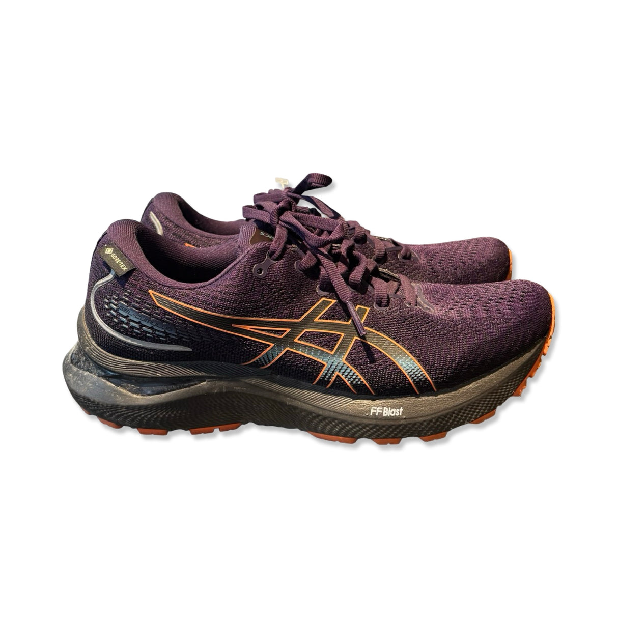 Purple Asics Gel-Cumulus 24 GTX women's running shoes with orange details, side view against a white background.
