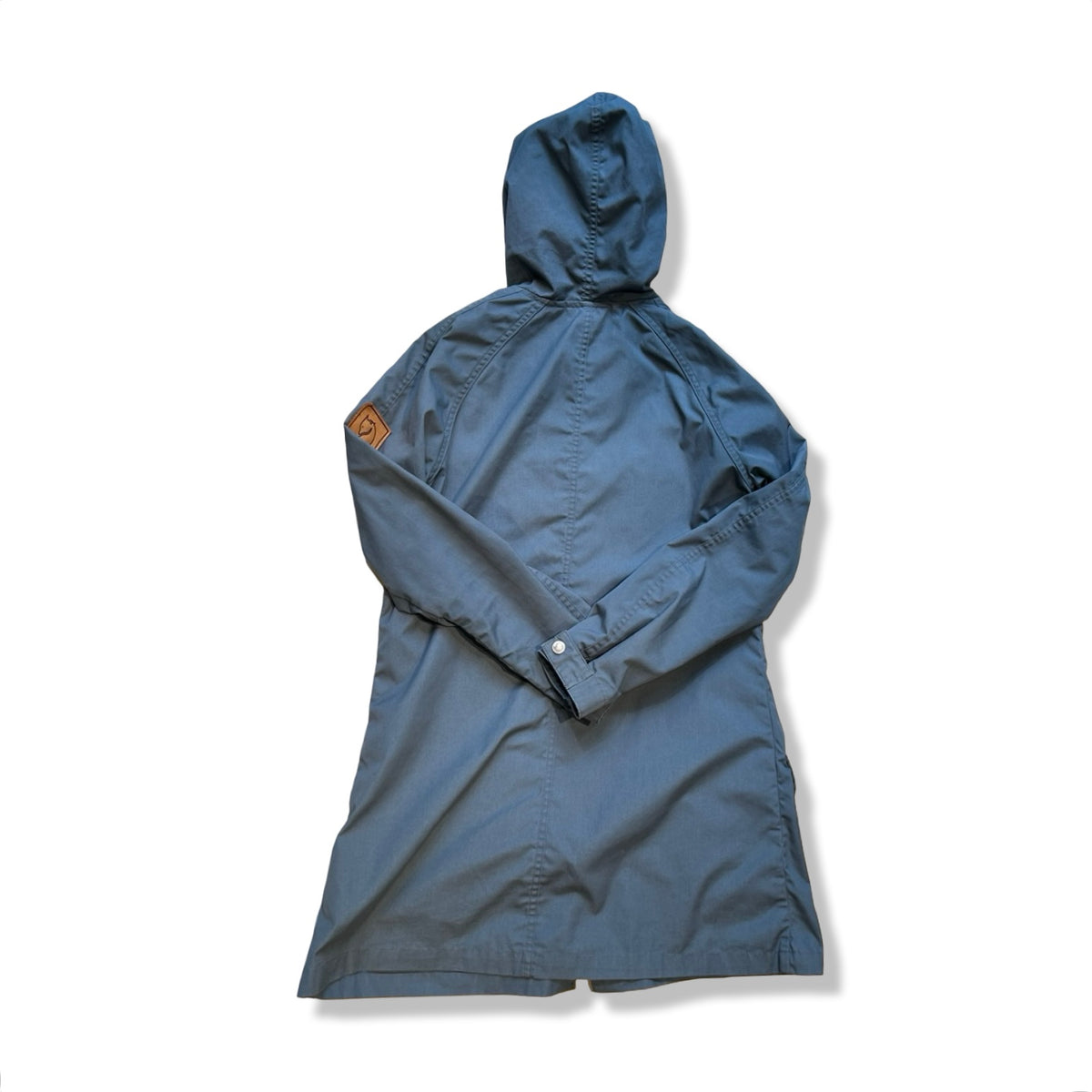 Baksidan av en blå Fjällräven Greenland Parka Light för dam med huva, fotograferad mot en vit bakgrund.
