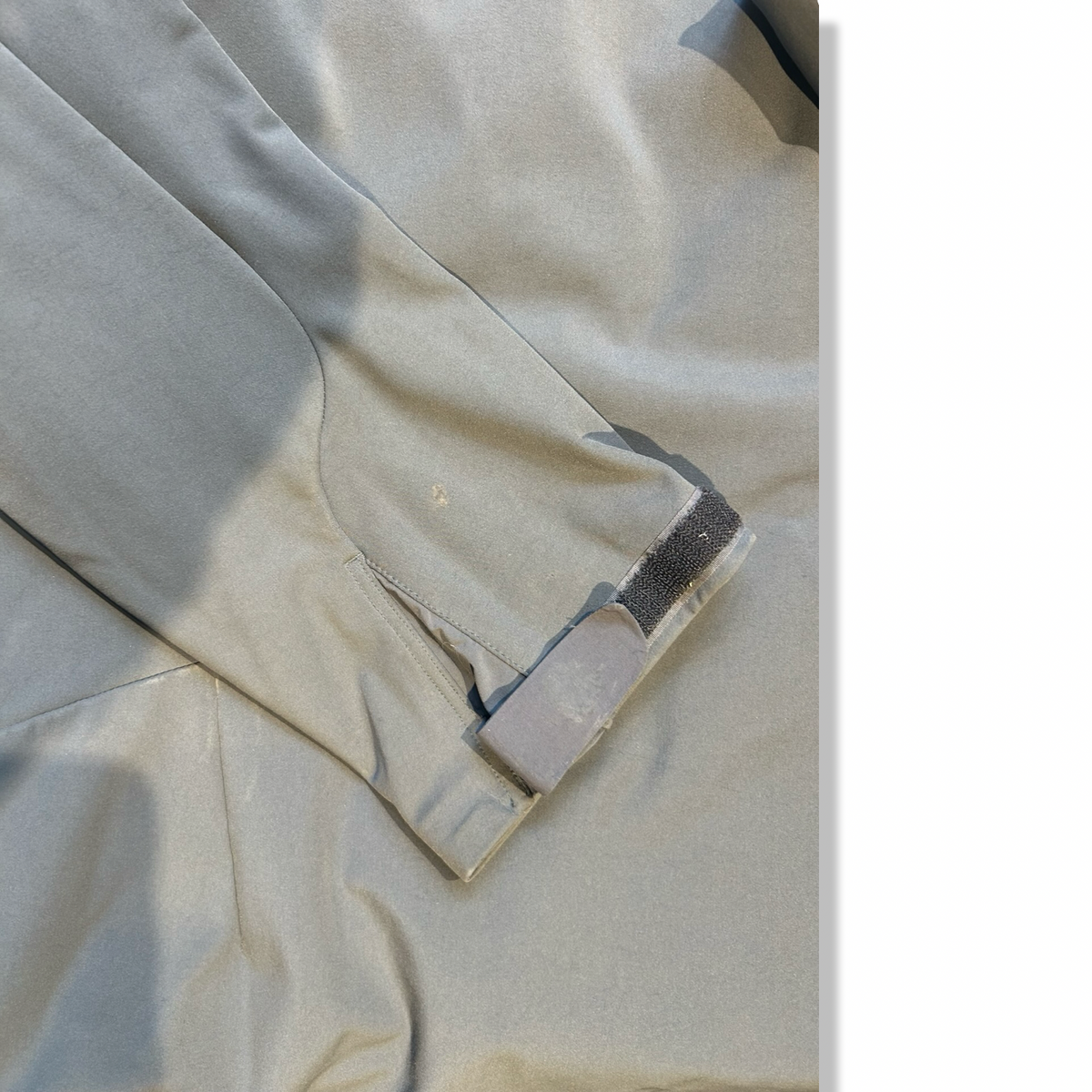 Close-up of the sleeve and cuff of the gray Haglöfs ROCA II Hood men's hybrid jacket, showing a stain.