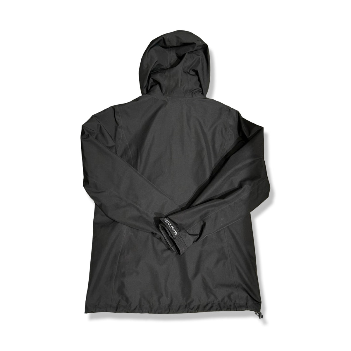 Baksidan av en svart skaljacka från Helly Hansen för dam med huva, fotograferad mot en vit bakgrund.