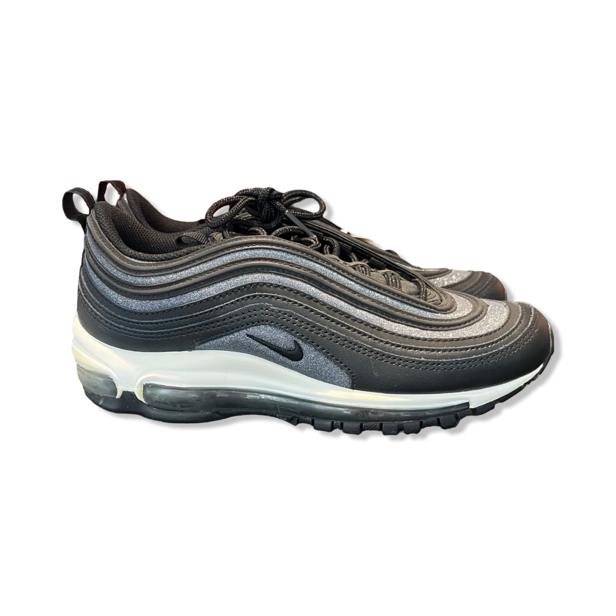 Women's Nike Air Max 97 sneakers in black and silver glitter, side view against a white background.