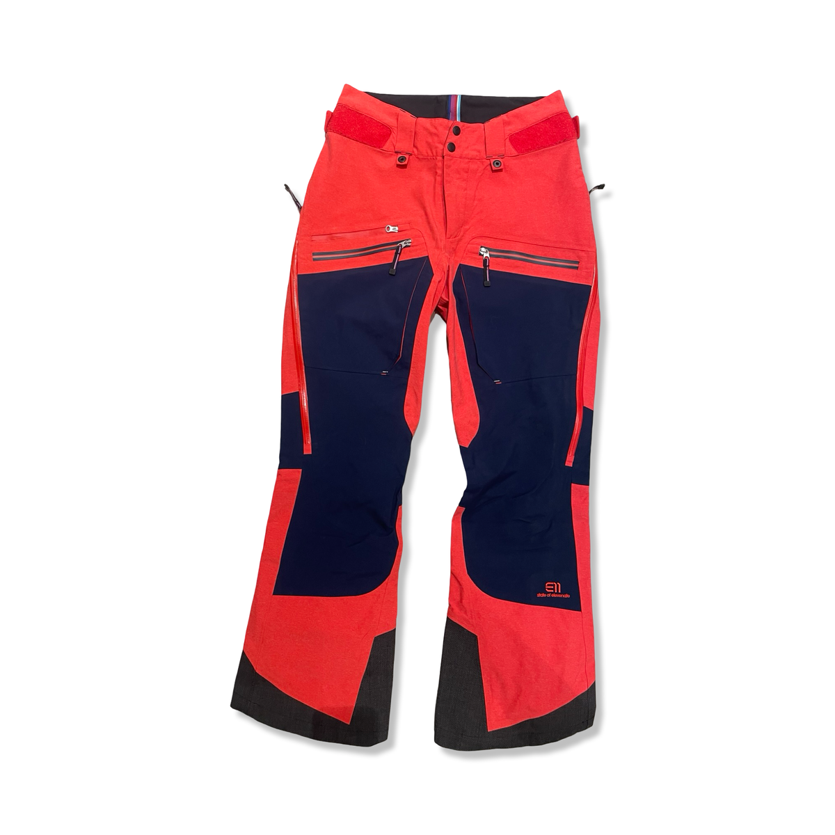 Orange and dark blue women's shell pants from Elevenate with front zippers, front view against a white background.