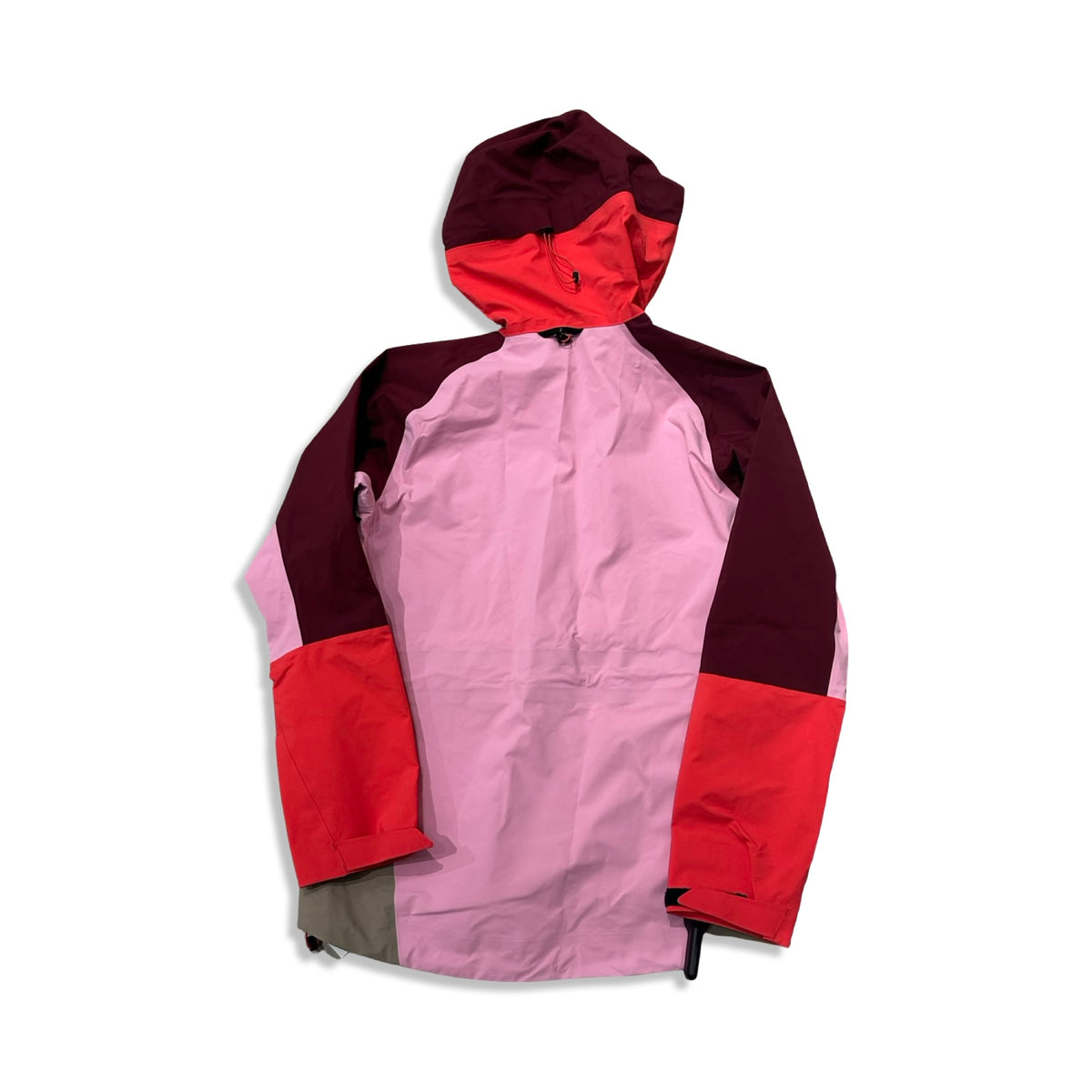 Back view of a pink, red and beige Peak Performance women's shell jacket against a white background.