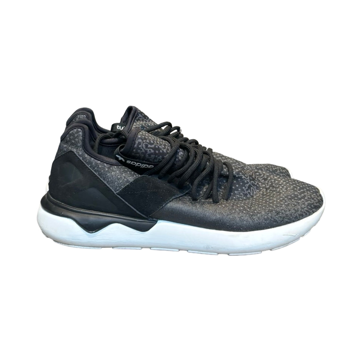 Svarta Adidas Tubular Runner träningsskor för herr med vit sula, fotograferade från sidan mot en vit bakgrund.