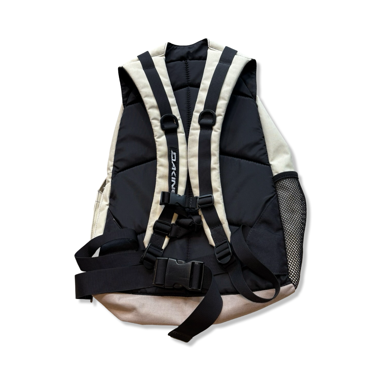 Beige and black Dakine backpack with padded shoulder straps and chest strap, back view against a white background.