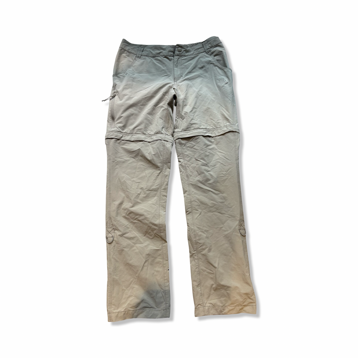 Beige zip-off vandringsbyxor från The North Face för dam, fotograferade framifrån mot vit bakgrund.