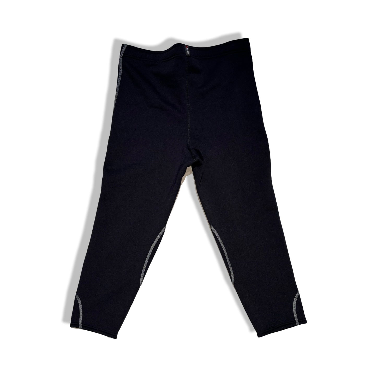 Baksidan av Houdini Drop underställsbyxa för dam i svart, fotograferad platt mot en vit bakgrund.