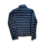 Baksidan av en blå dunjacka från Woolrich i storlek L, fotograferad mot en vit bakgrund.