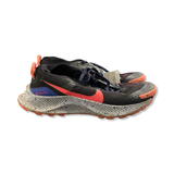 Svart damlöparsko Nike Pegasus Trail Gore-Tex med orangea och blå detaljer samt stänkmönstrad sula, fotograferad från sidan mot vit bakgrund.