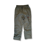 Green Fjällräven women's shell pants with elastic waistband and drawstring, front view against a white background.