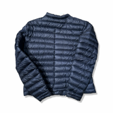 Back view of a blue Peak Performance women's down jacket against a white background.