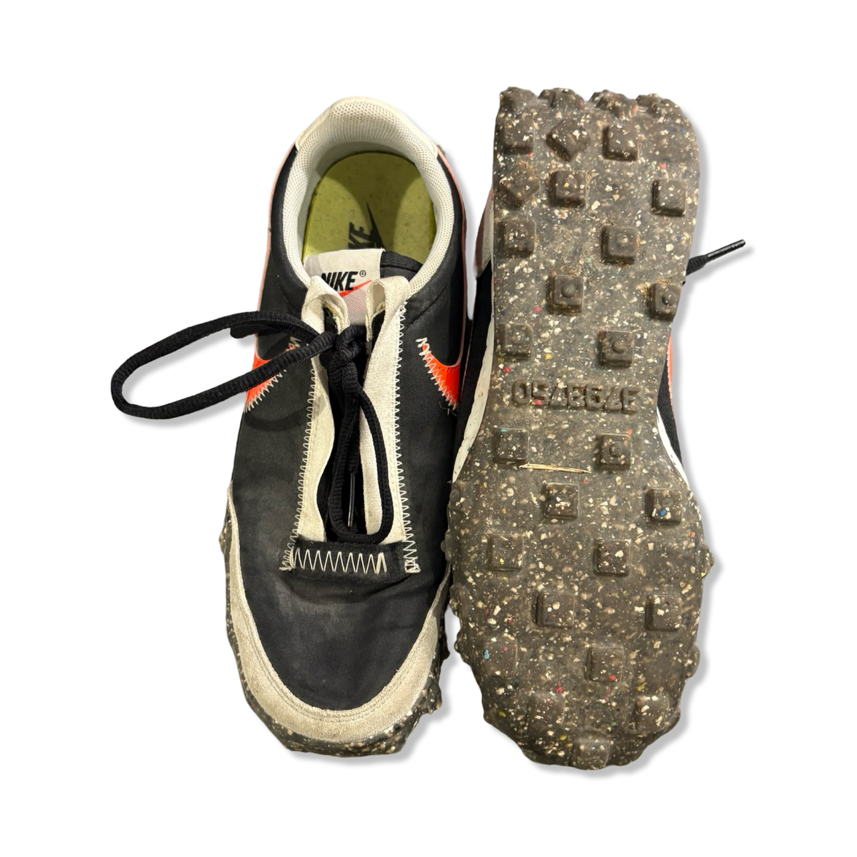 Grey and black Nike Waffle Racer Crater women's running shoes, front view with the sole facing upwards against a white background.