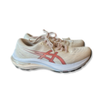 Beige löparskor Asics GT-2000 11 för dam med rosa detaljer, fotograferade från sidan mot en vit bakgrund.