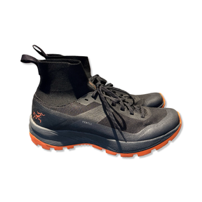 Black Arc'teryx women's Vertex trail running hiking shoes with orange details, side view against a white background.