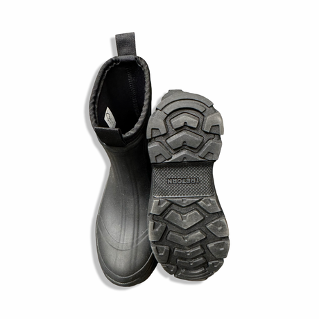 Black Tretorn Terrain Low Neo women's rubber boots, shown from above with focus on the patterned sole against a white background.