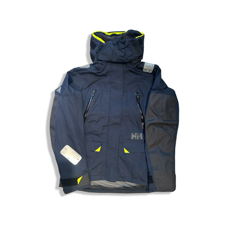 Mörkblå seglarjacka Helly Hansen Skagen offshore för dam med reflexdetaljer, fotograferad framifrån mot en vit bakgrund.