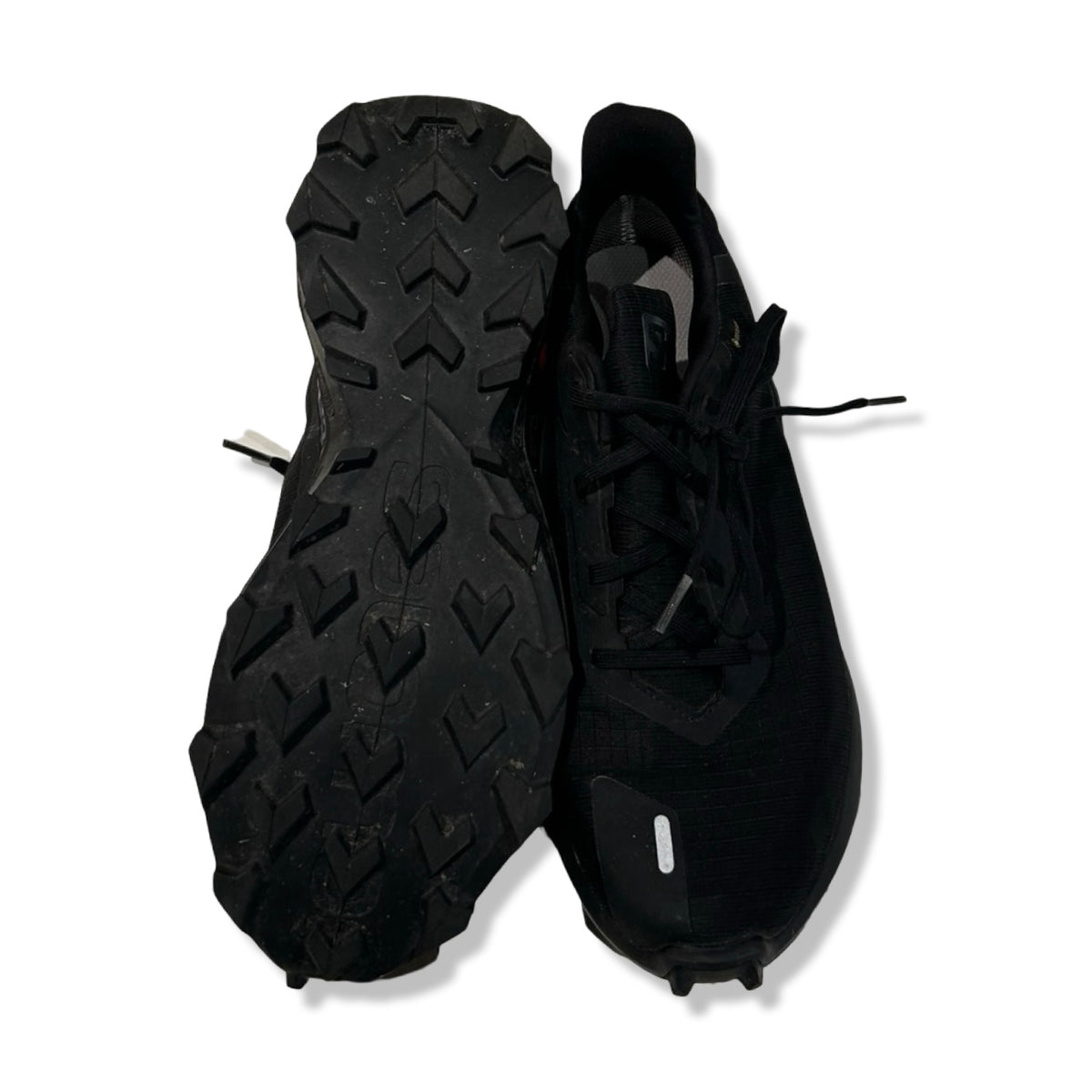 Svarta löparskor Salomon Alpha Cross 3 för dam, visade med undersidan och ovansidan mot vit bakgrund.
