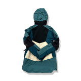 Back view of a blue and white Peak Performance women's hooded shell jacket against a white background.
