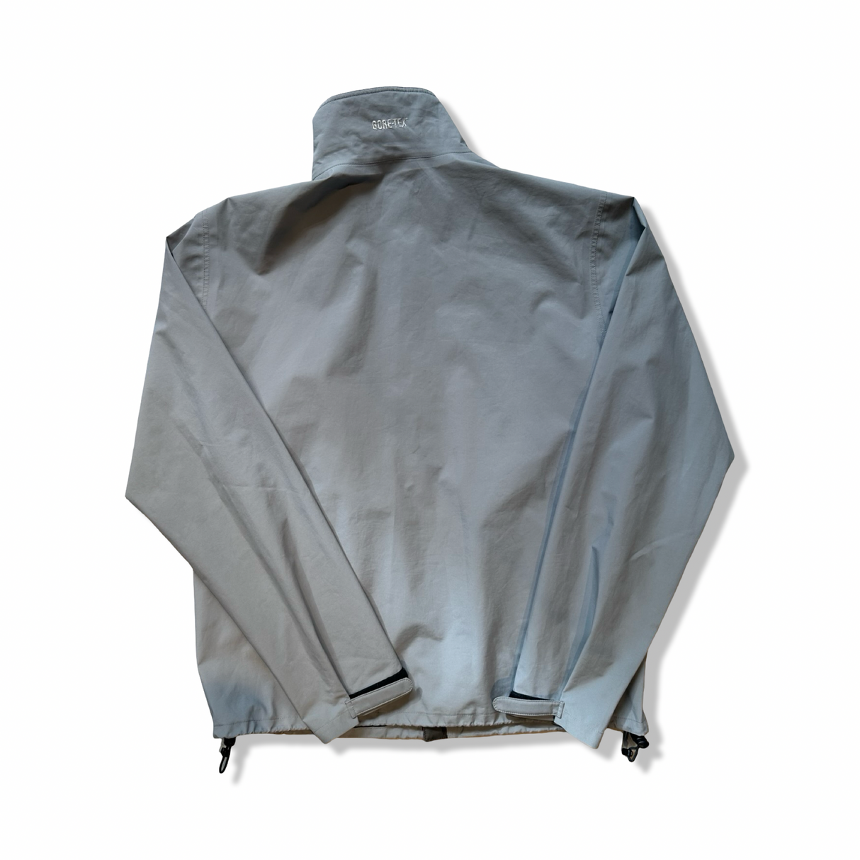 Grey Peak Performance men's shell jacket with Gore-Tex detail on the back collar, back view against a white background.