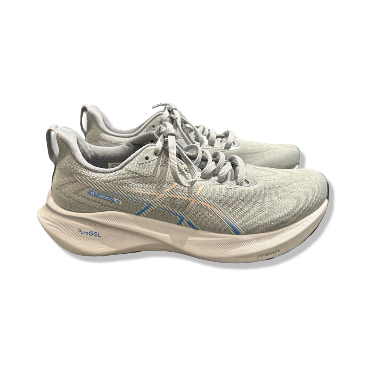 Grå löparskor Asics GT-2000 13 för dam med dämpad sula, fotograferade från sidan mot en vit bakgrund.