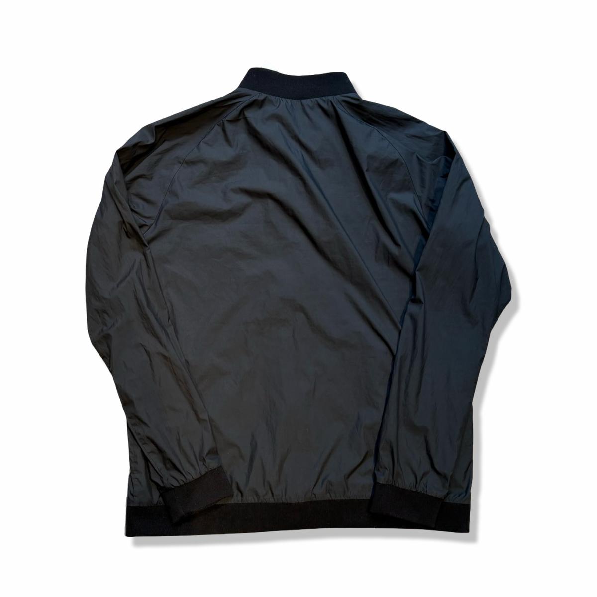 Black Peak Performance training jacket, back view against a white background.