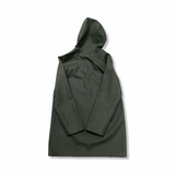 Baksidan av en grön regnkappa från Stutterheim för dam i modell Stockholm, fotograferad mot en vit bakgrund.