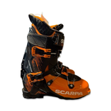Orange och svarta Scarpa Mastrale toppturspjäxor för herr, fotograferade från sidan mot en vit bakgrund.