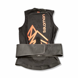 Back view of a black Salomon junior back protector with orange details, photographed against a white background.