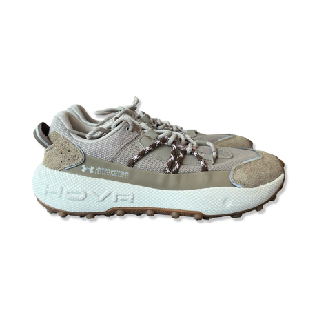 A pair of beige Under Armour men's sneakers with a chunky sole, photographed from the side against a white background.