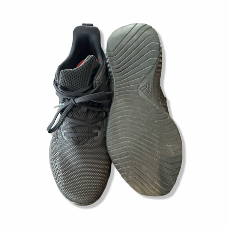 Black Adidas running shoes with a mesh upper and patterned rubber sole, photographed from above against a white background.