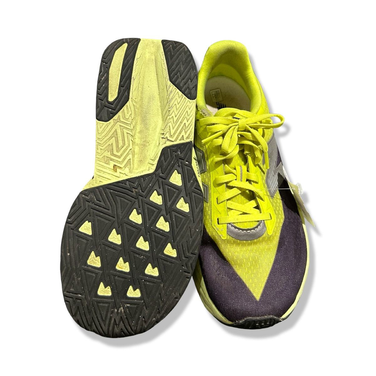 A pair of yellow New Balance FuelCell Rebel men's running shoes, shown with an outsole and an upper against a white background.