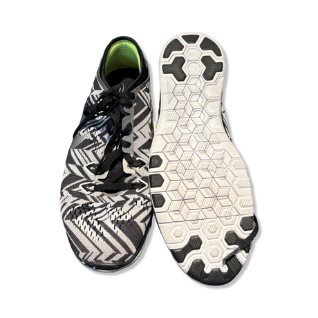 Svart- och vita Nike Free 5.0 Tr Fit träningsskor för dam med mönstrad ovandel och flexibel sula där en sko visar undersidan.