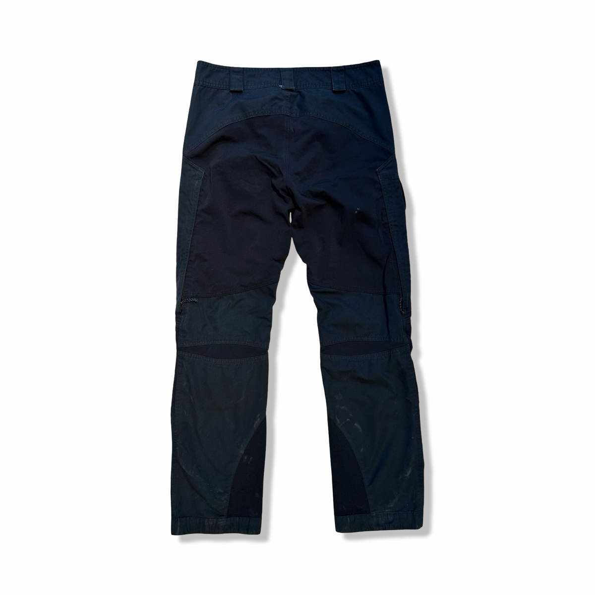 Baksidan av ett par svarta Lundhags Traverse Pant funktionsbyxor för dam, fotograferade mot en vit bakgrund.