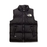 Svart väst från The North Face Teen 1996 Retro Nuptse för barn, fotograferad framifrån mot en vit bakgrund.