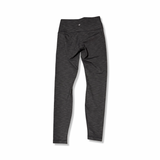 Baksidan av grå träningstights från Lululemon för dam, fotograferade mot en vit bakgrund.