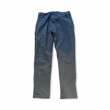 Blue men's functional trousers by Luxer with zippered pockets, rear view against a white background.