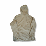 Baksidan av en beige anorak från Fjällräven i modell High Coast Lite för dam, fotograferad mot vit bakgrund.