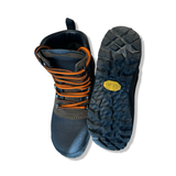 Brown and black Lundhags Tjakke Mid women's hiking boots with orange laces, shown from above with the sole against a white background.