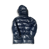 Baksidan av en blå dunjacka från Moncler med huva, fotograferad mot en vit bakgrund.