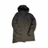 Black women's down jacket from Peak Performance with a hood, photographed from the front against a white background.