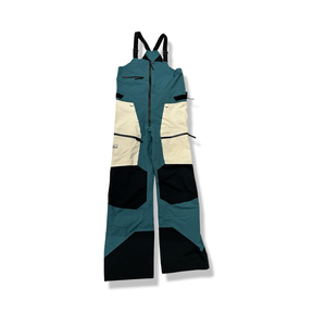 Blue and white Peak Performance women's bib shell pants, front view against a white background.