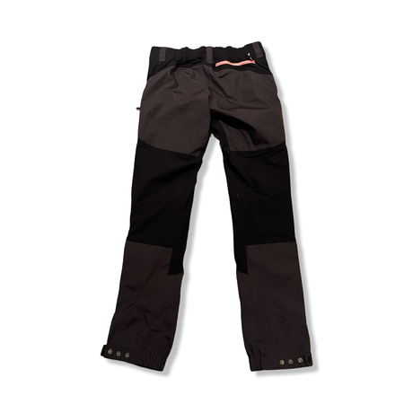 Back view of a black and brown RevolutionRace women's hiking trousers against a white background.